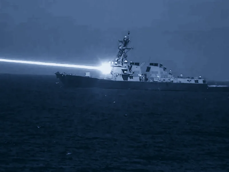 A destroyer firing a laser, seen through an infrared camera